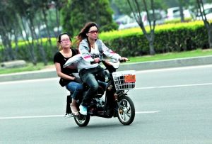 昨日，通州新华联小区，市民骑着电动自行车在马路上行驶。本报记者
