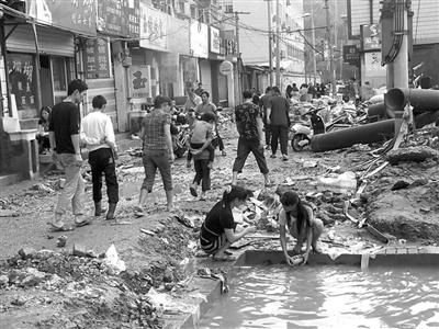 今天早上，由于供水还未恢复，当地居民只能在脏水池里清洗物品。