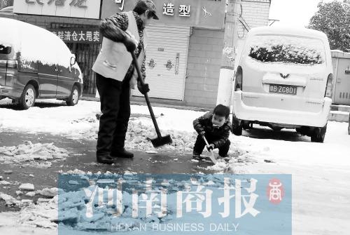 郑州一处过街天桥 一位女士带着孩子为路人铲雪
