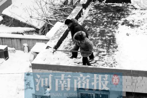 郑州一处过街天桥 一位女士带着孩子为路人铲雪
