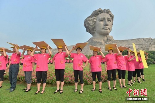 广场舞大妈在毛泽东雕像前用人体队形拼字。