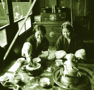 康定藏族女锅庄主酥姬敦白在自家锅庄食堂和女儿一起喝酥油茶吃糌粑。